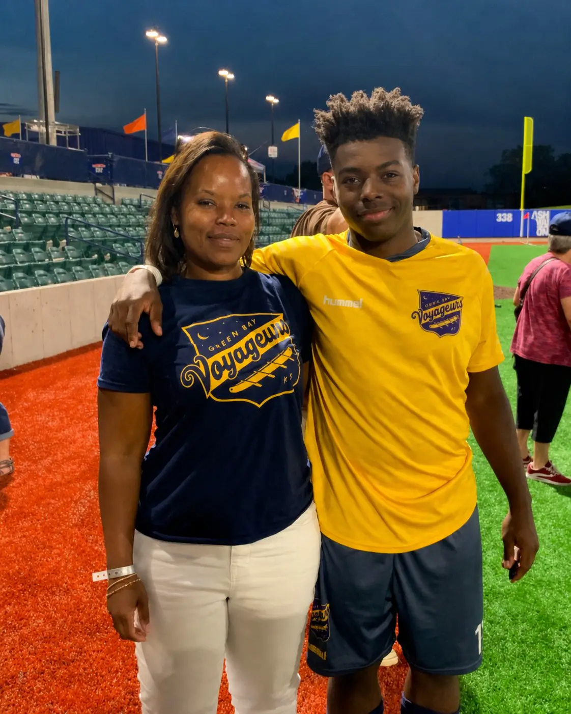 April Kigeya with a family member at a soccer stadium